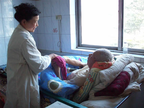 陪护人员在给老人擦洗