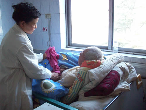 陪护人员在给老人擦洗