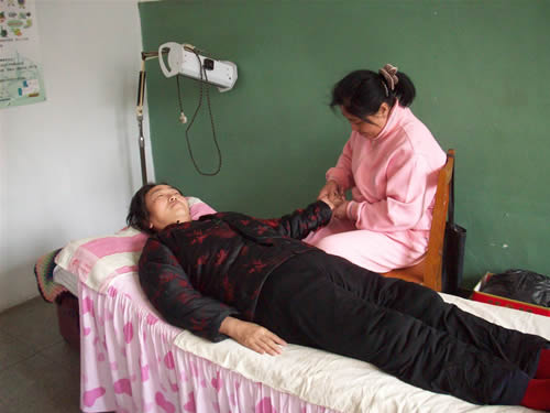 陪护人员在给偏瘫老人进行按摩,老年精神病，老年优待证